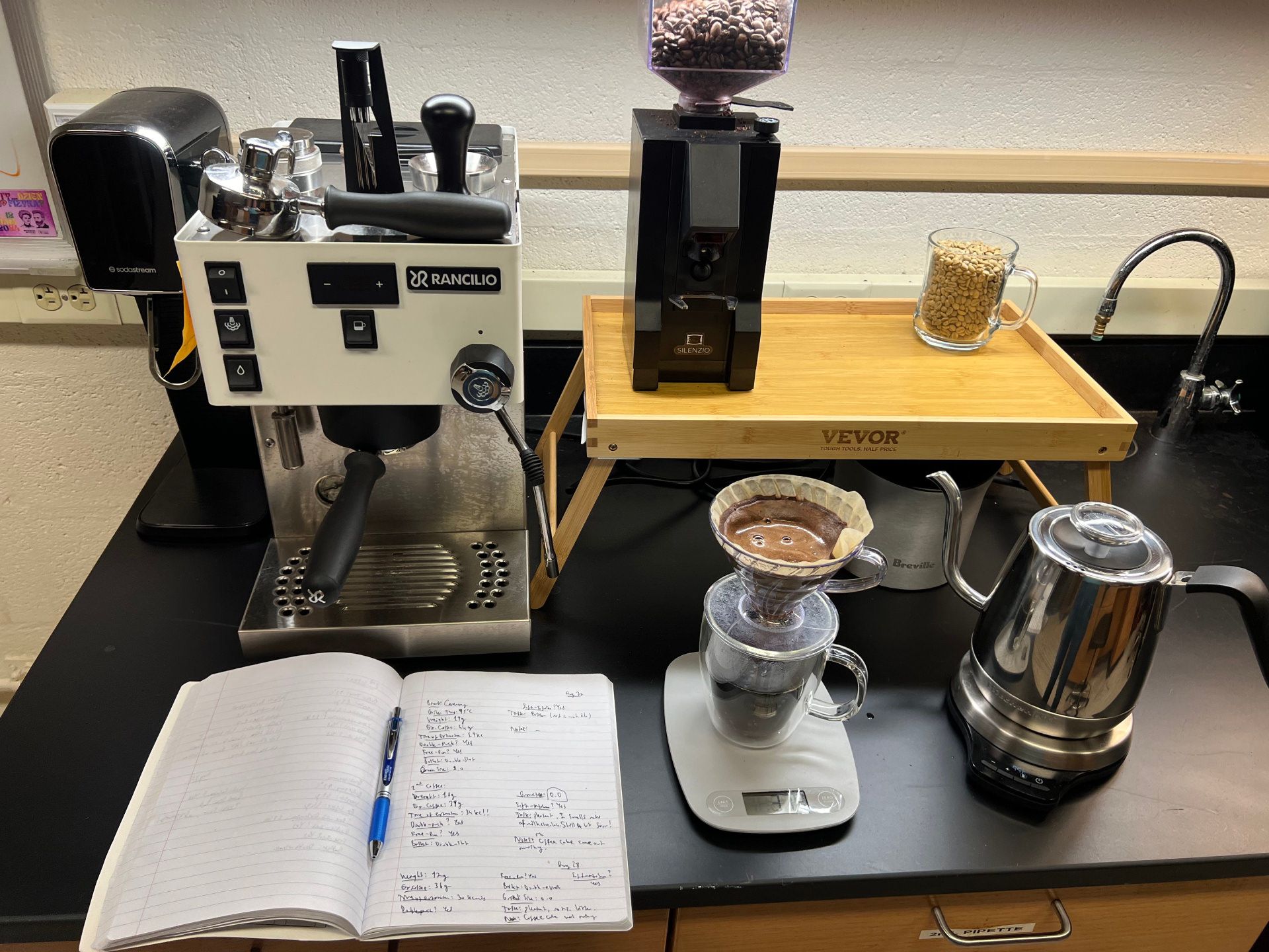 دانه قهوه و تجهزات دم آوری قهوه و دفتر یادداشت در آزمایشگاه