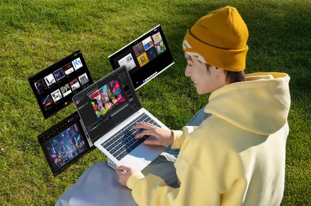 لپ‌تاپ ایسوس ویوو بوک ۱۶ (Asus Vivobook 16) در فضای باز روی چمن